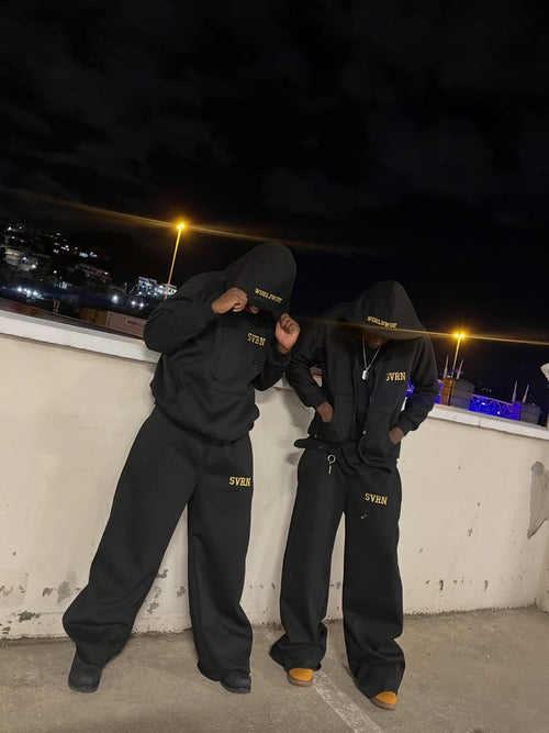 SVRN Worldwide black tracksuit set worn on rooftop at night
